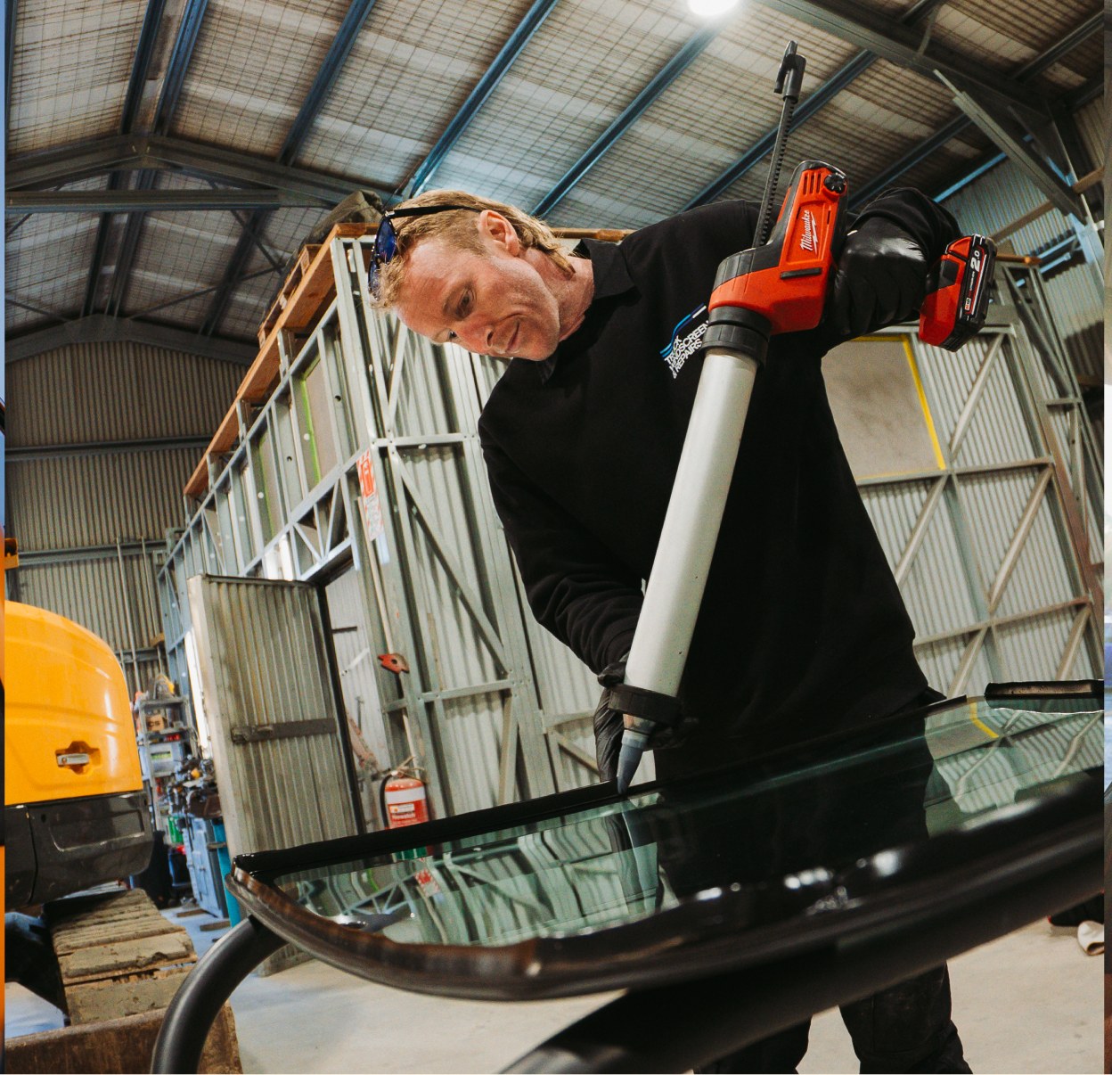 Technician applying adhesive to a windscreen